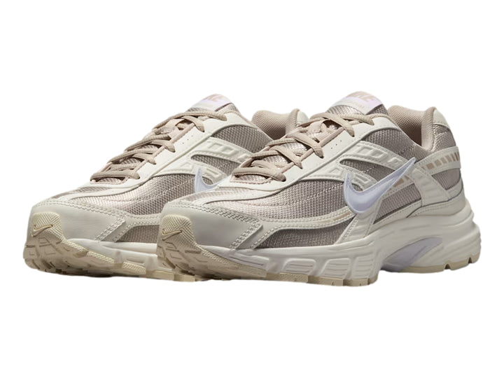 Tenis Nike Initiator color beige y blanco con suela gruesa, vista lateral.