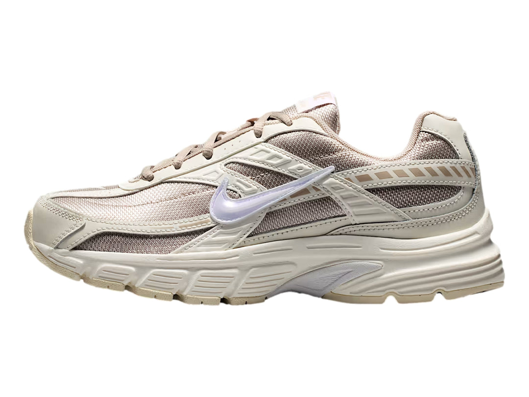 Tenis Nike Initiator color beige y blanco con suela gruesa, vista lateral.