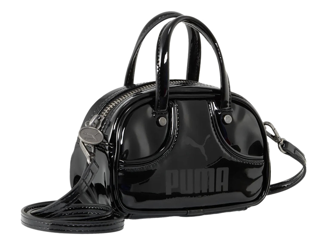 Bolso pequeño PUMA de color negro brillante con asa superior y correa ajustable.