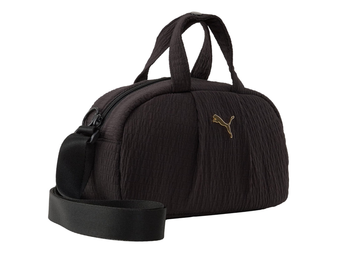 Bolso mini grip PUMA color negro con asas superiores, correa ajustable y logo dorado.