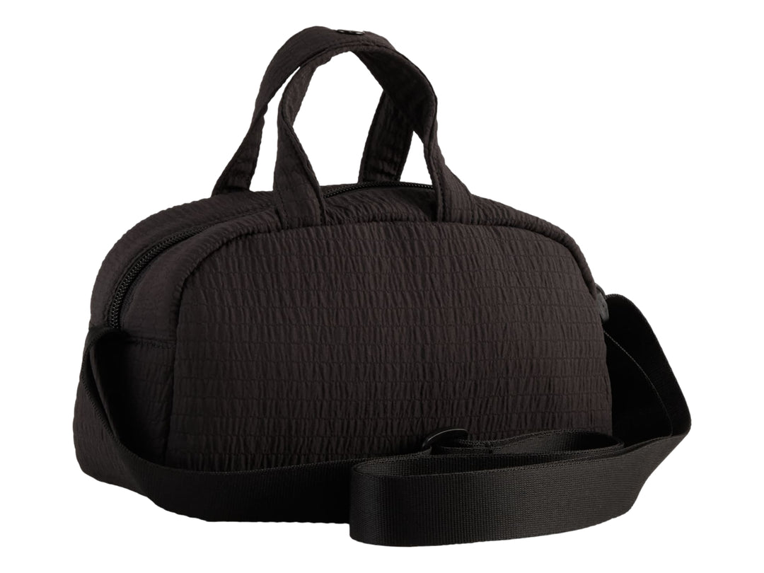 Bolso mini grip PUMA color negro con asas superiores, correa ajustable y logo dorado.