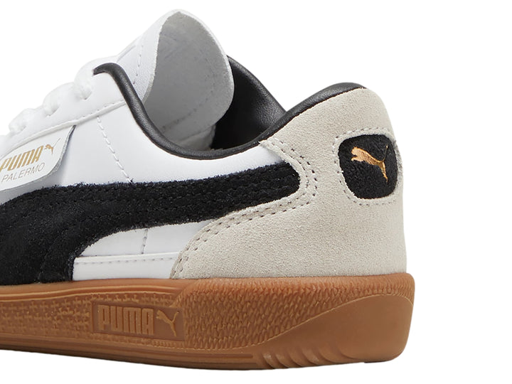 Tenis PUMA blancos y grises con suela de goma color marrón.