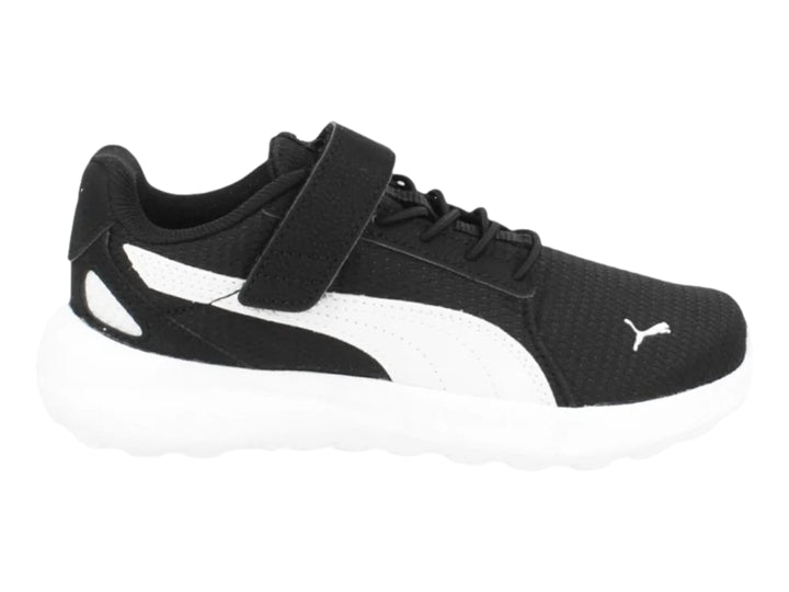 Tenis PUMA color negro con suela y franja blanca, cierre de velcro y agujetas para niños.
