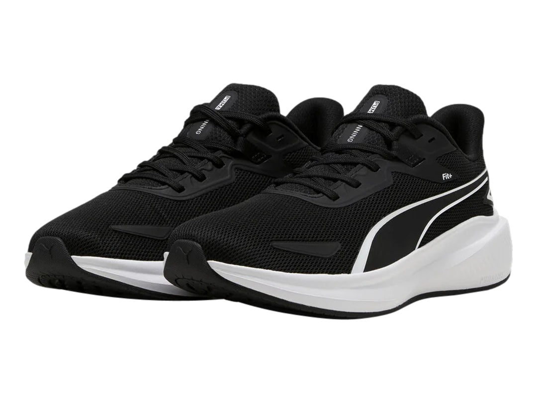 Tenis deportivos PUMA color negro con suela blanca y logotipo blanco en el costado.