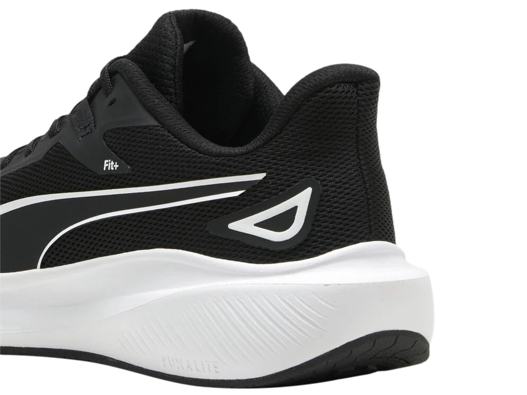 Tenis deportivos PUMA color negro con suela blanca y logotipo blanco en el costado.