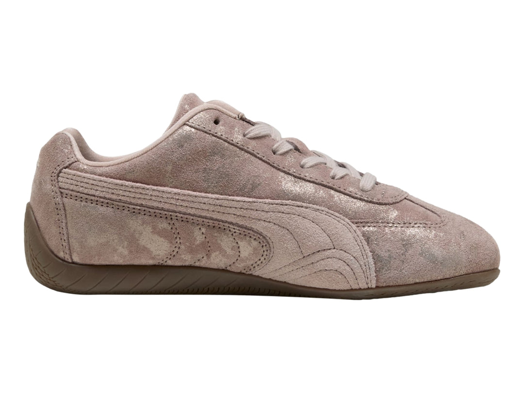 Tenis PUMA Speedcat color rosa latte con detalles en cromo y suela de goma marrón.