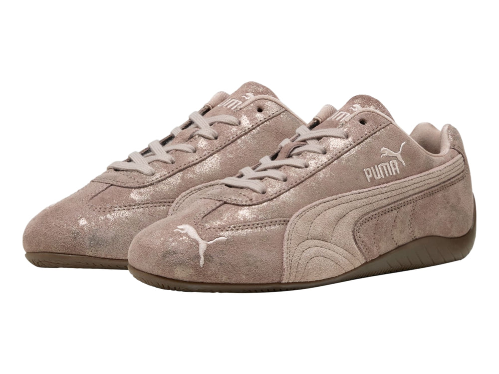 Tenis PUMA Speedcat color rosa latte con detalles en cromo y suela de goma marrón.