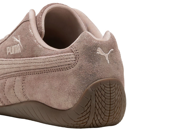 Tenis PUMA Speedcat color rosa latte con detalles en cromo y suela de goma marrón.
