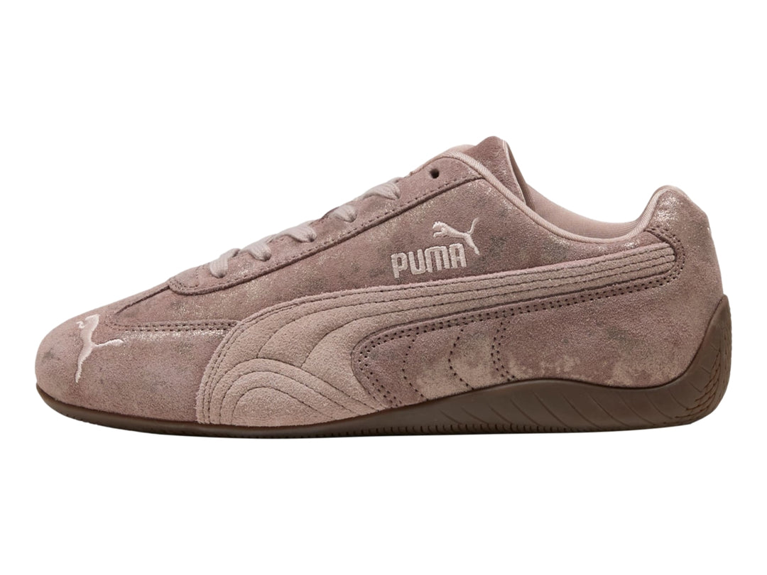 Tenis PUMA Speedcat color rosa latte con detalles en cromo y suela de goma marrón.