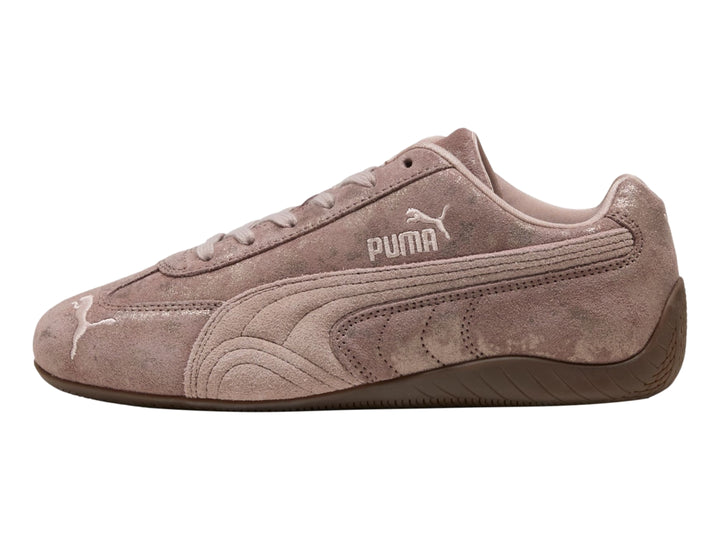 Tenis PUMA Speedcat color rosa latte con detalles en cromo y suela de goma marrón.