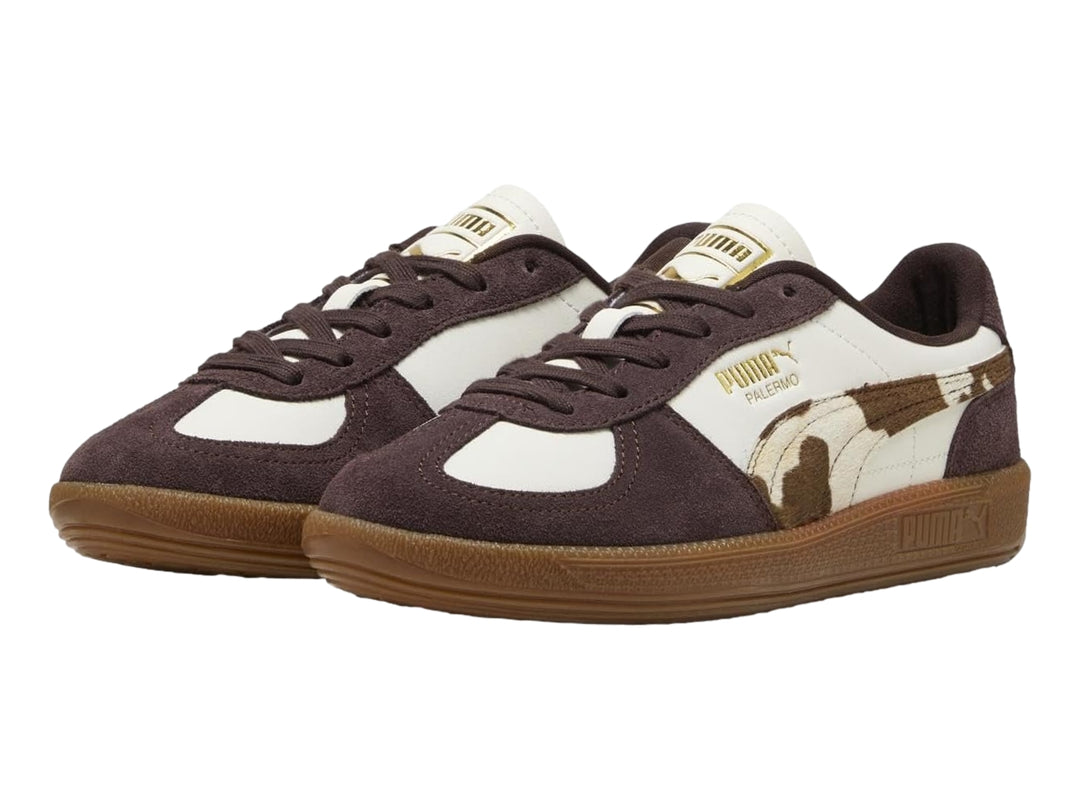 Tenis PUMA Palermo en color blanco y marrón chocolate con estampado de vaca y suela de goma.