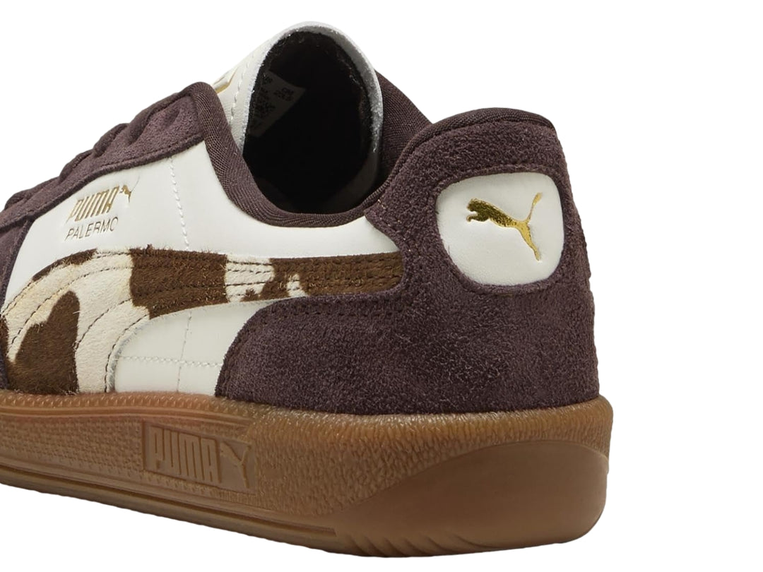 Tenis PUMA Palermo en color blanco y marrón chocolate con estampado de vaca y suela de goma.