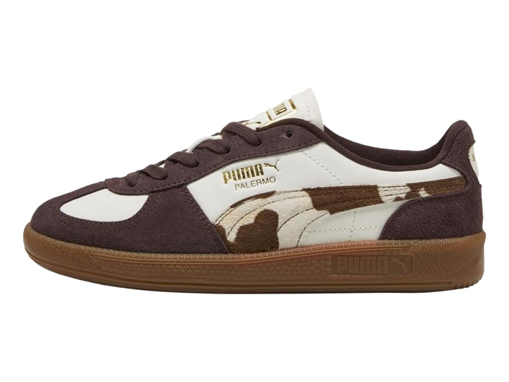 Tenis PUMA Palermo en color blanco y marrón chocolate con estampado de vaca y suela de goma.