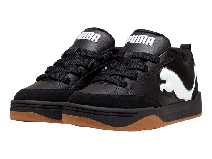 Tenis PUMA negros con suela color marrón y logotipo blanco en el costado.