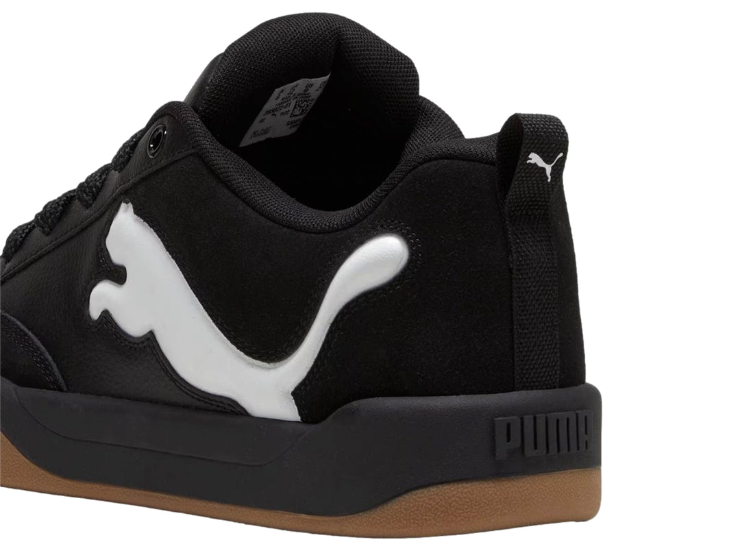 Tenis PUMA negros con suela color marrón y logotipo blanco en el costado.