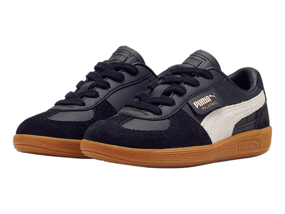 Tenis PUMA Palermo color negro con suela de goma café y franja lateral gris.
