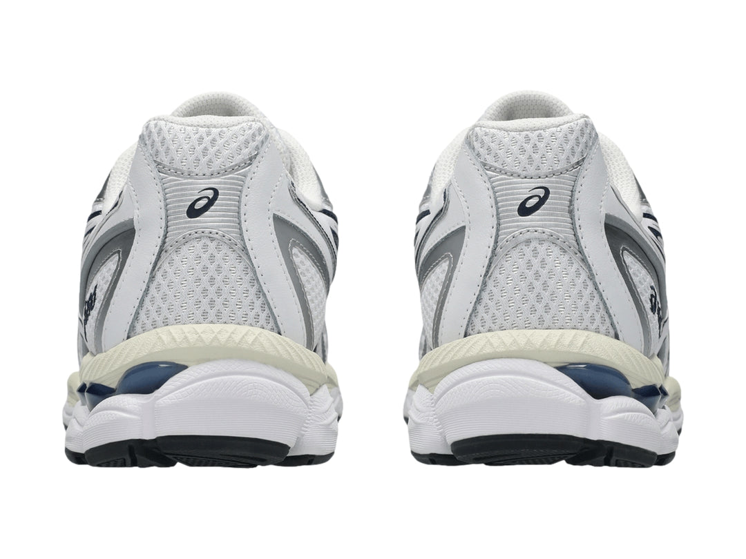 Tenis ASICS GEL-NYC 2055 color blanco con rayas azul marino y detalles plateados.