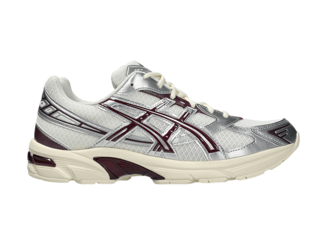 Tenis ASICS GEL-1130 color crema y plata con detalles en morado y suela blanca.