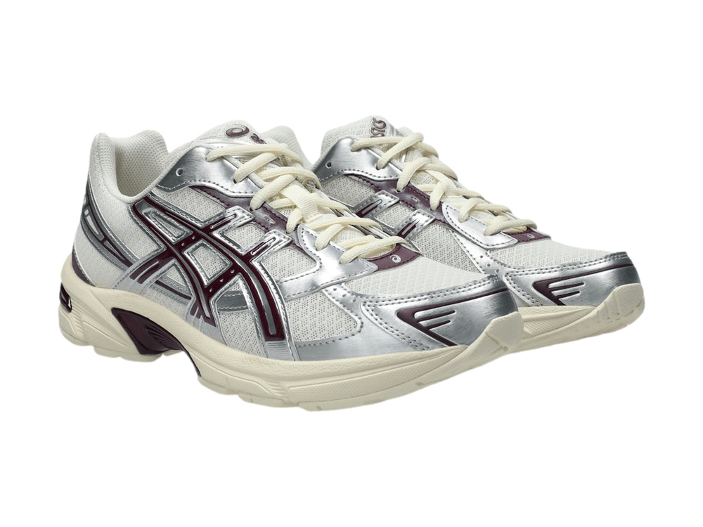 Tenis ASICS GEL-1130 color crema y plata con detalles en morado y suela blanca.