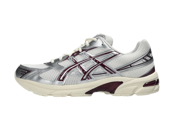 Tenis ASICS GEL-1130 color crema y plata con detalles en morado y suela blanca.
