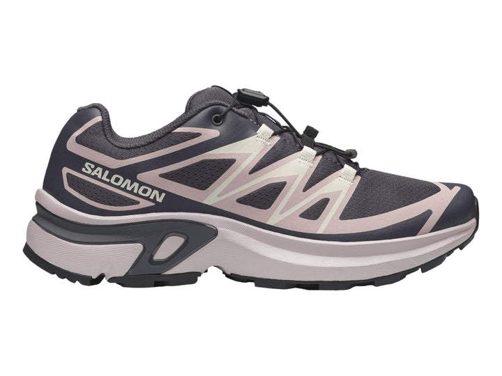 Tenis deportivos Salomon color gris oscuro y beige con suela gruesa y cordones negros.