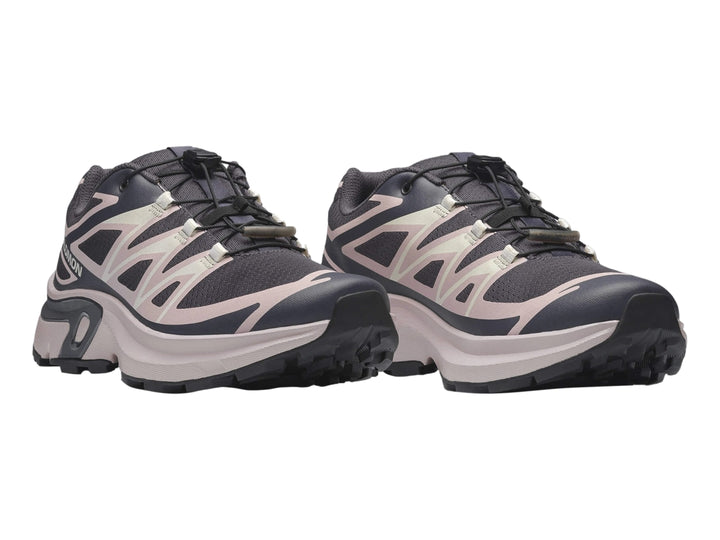 Tenis deportivos Salomon color gris oscuro y beige con suela gruesa y cordones negros.