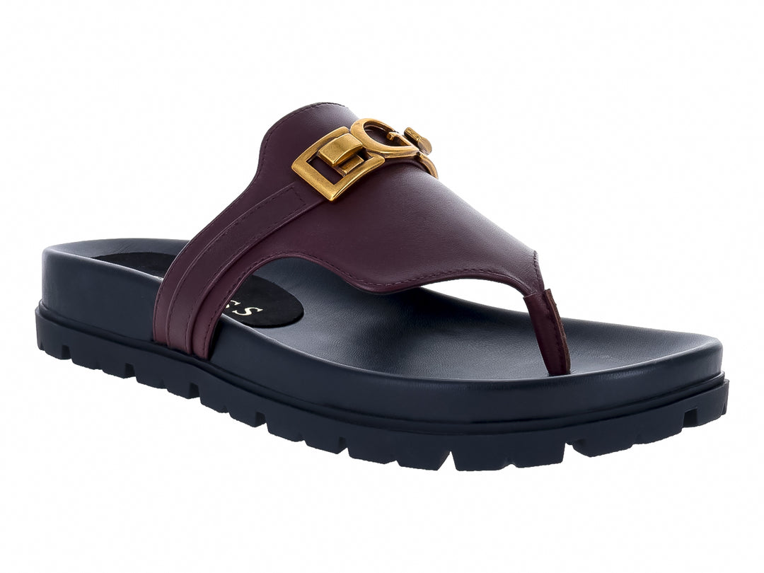 Sandalias Guess color vino con suela negra gruesa y hebilla dorada para mujer.