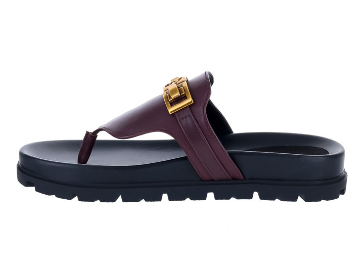 Sandalias Guess color vino con suela negra gruesa y hebilla dorada para mujer.