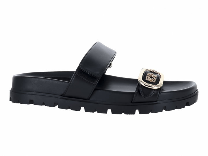 Sandalias negras Guess con suela track gruesa y hebilla dorada decorativa.