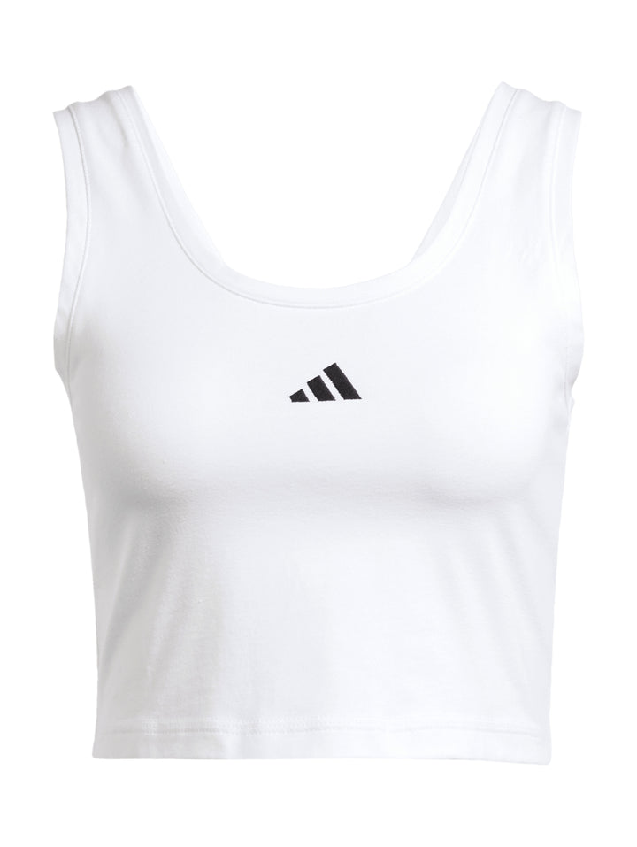 Mujer vistiendo un top corto blanco sin mangas de la marca Adidas.