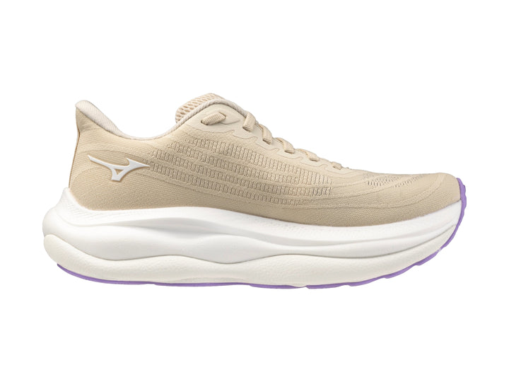 Tenis deportivos Mizuno Wave Sky 9 color arena y blanco con suela morada para mujer.