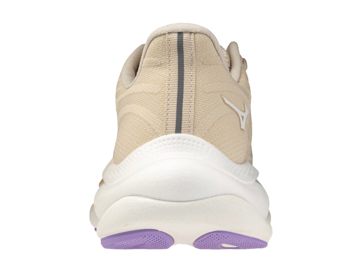 Tenis deportivos Mizuno Wave Sky 9 color arena y blanco con suela morada para mujer.