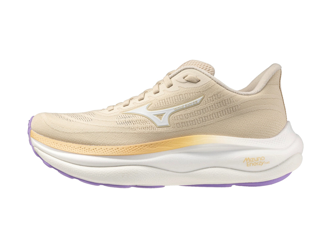 Tenis deportivos Mizuno Wave Sky 9 color arena y blanco con suela morada para mujer.