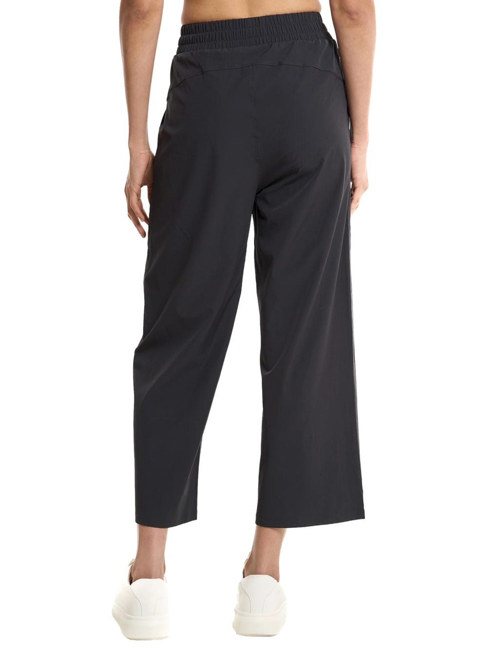 Mujer vistiendo pantalones deportivos Everlast de color negro con pierna ancha y cintura elástica.