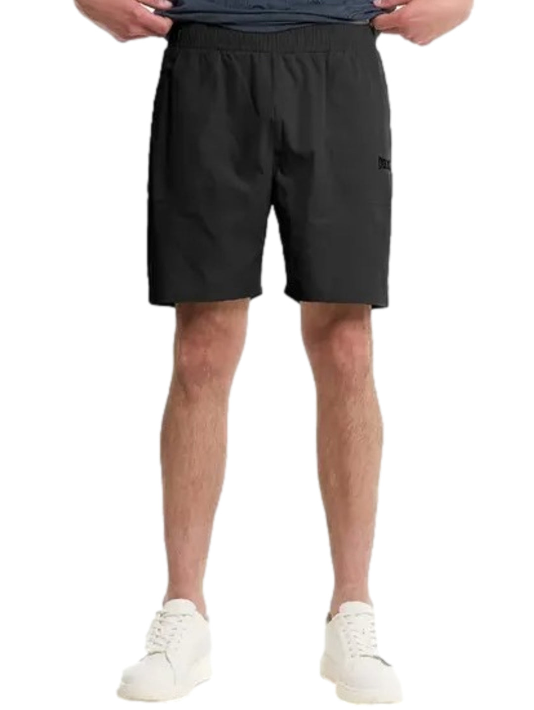 Hombre vistiendo shorts deportivos negros de Everlast y tenis blancos.