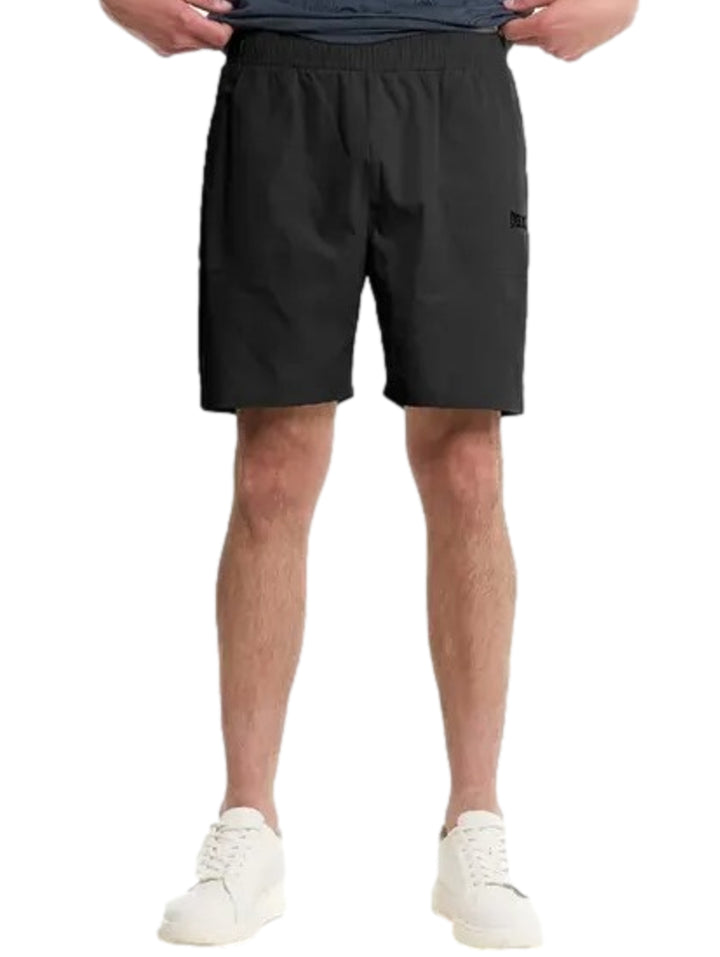 Hombre vistiendo shorts deportivos negros de Everlast y tenis blancos.