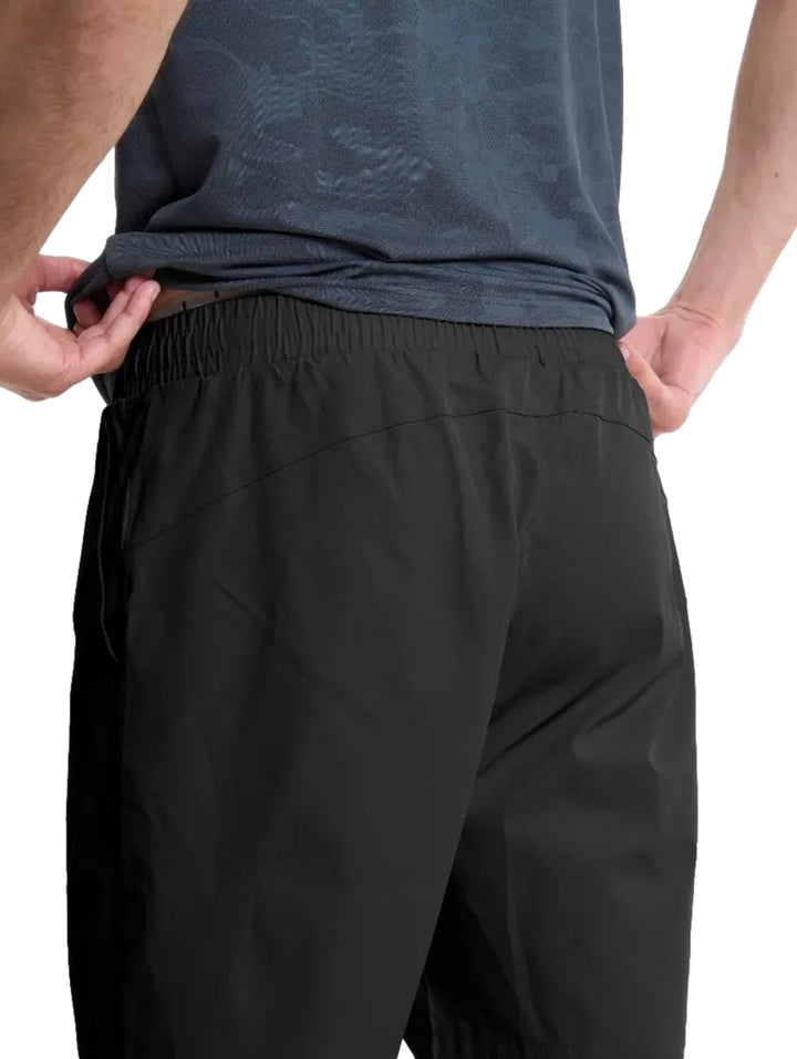 Hombre vistiendo shorts deportivos negros de Everlast y tenis blancos.