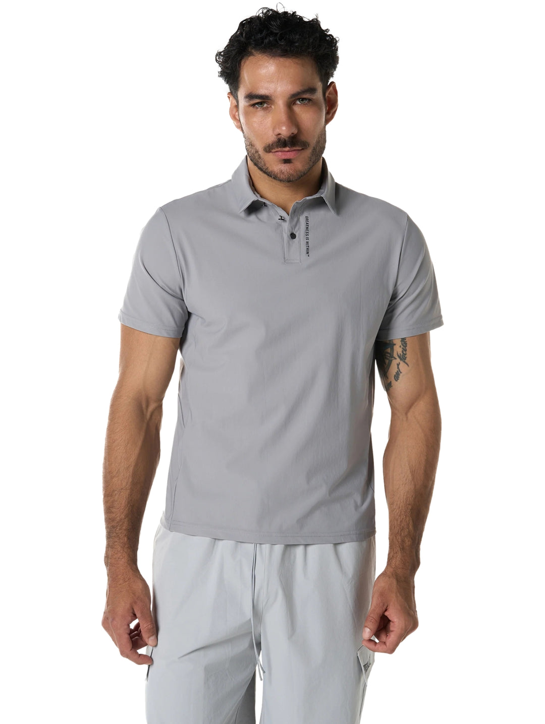 Hombre vistiendo playera polo deportiva color gris de la marca Everlast.