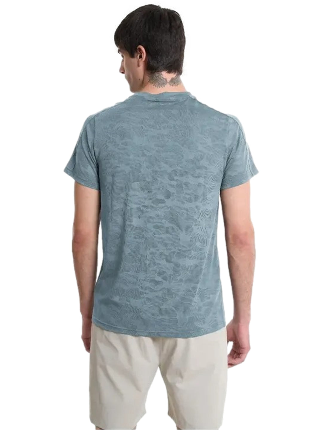 Hombre vistiendo playera deportiva azul de marca Everlast y shorts beige.