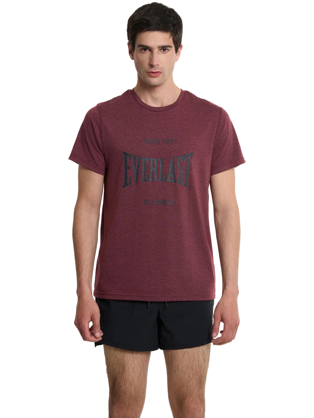 Hombre vistiendo una camiseta deportiva de color rojo oscuro con el logo de Everlast en el pecho.