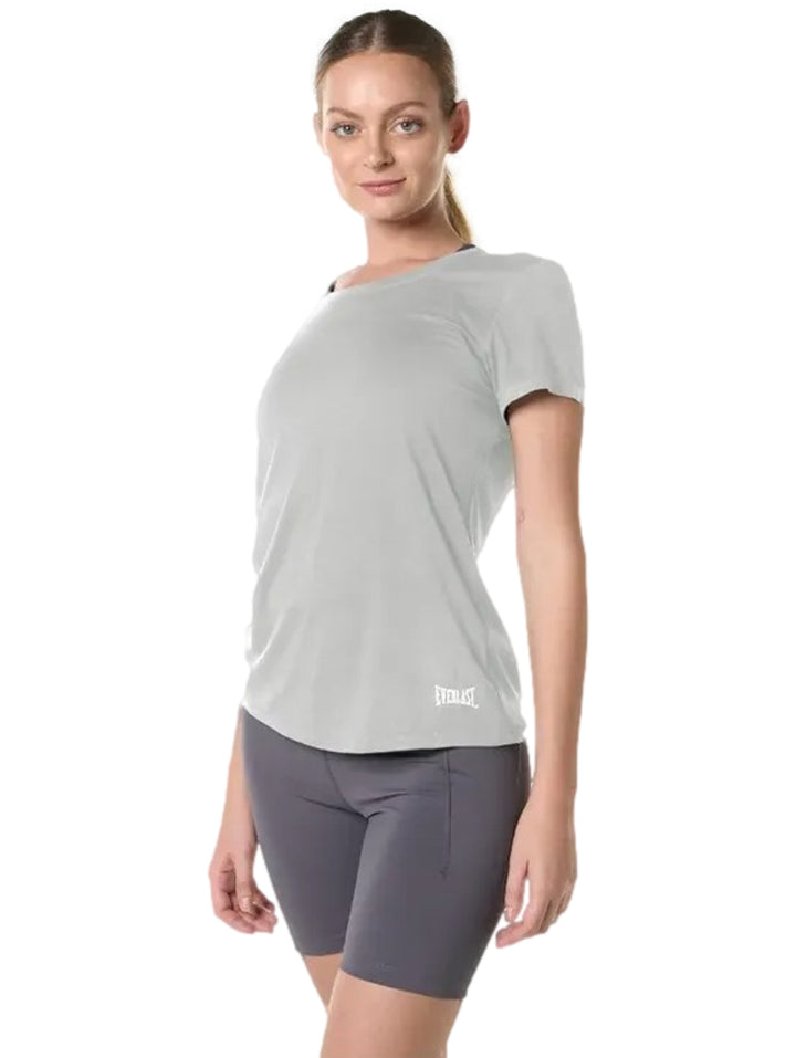 Mujer vistiendo camiseta deportiva gris claro de manga corta marca Everlast.