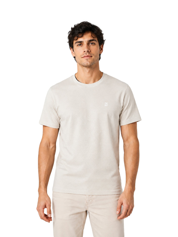 Hombre vistiendo playera de manga corta color pebble de la marca DKNY.