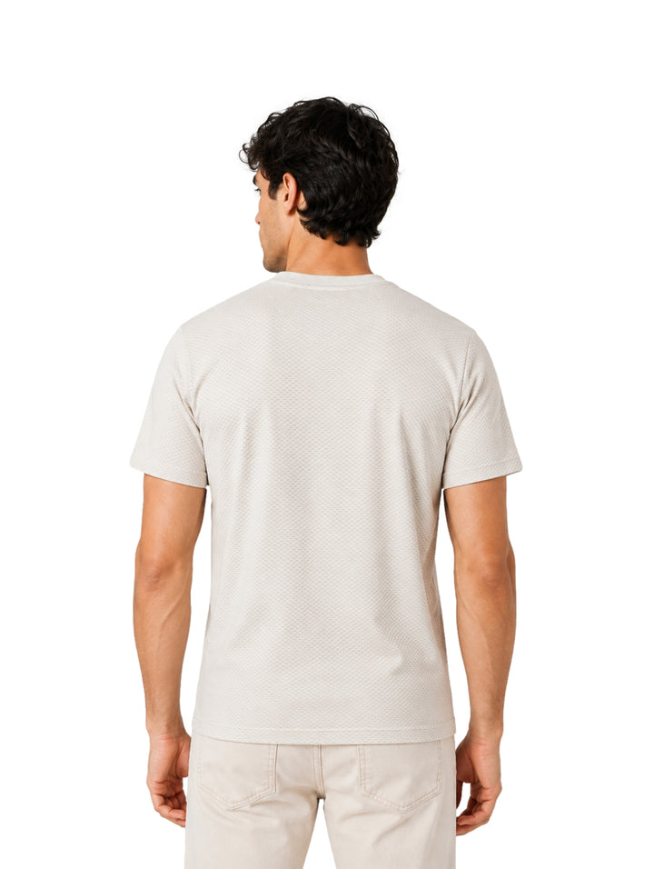 Hombre vistiendo playera de manga corta color pebble de la marca DKNY.