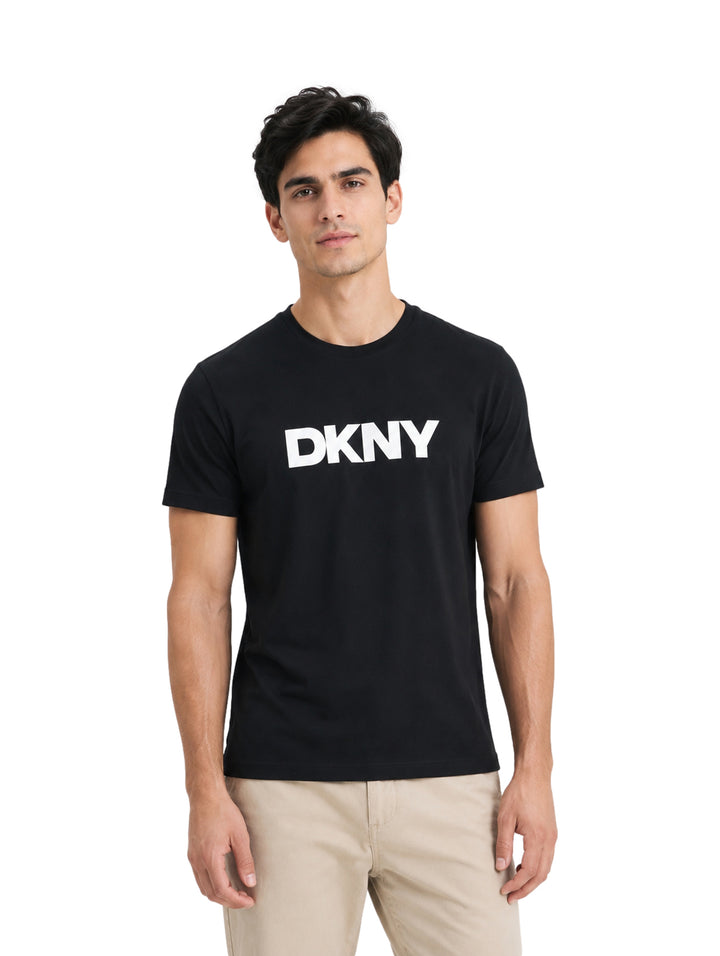 Hombre vistiendo una playera negra de manga corta con el logotipo de DKNY en blanco en el pecho.