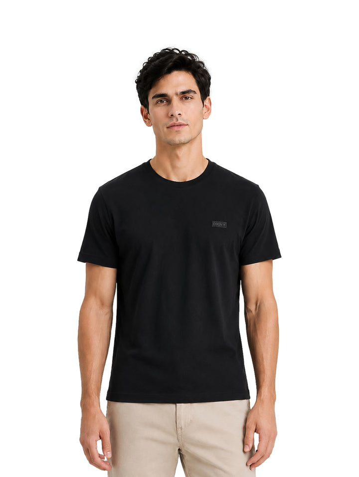 Hombre vistiendo una playera DKNY de color negro con cuello redondo y manga corta.