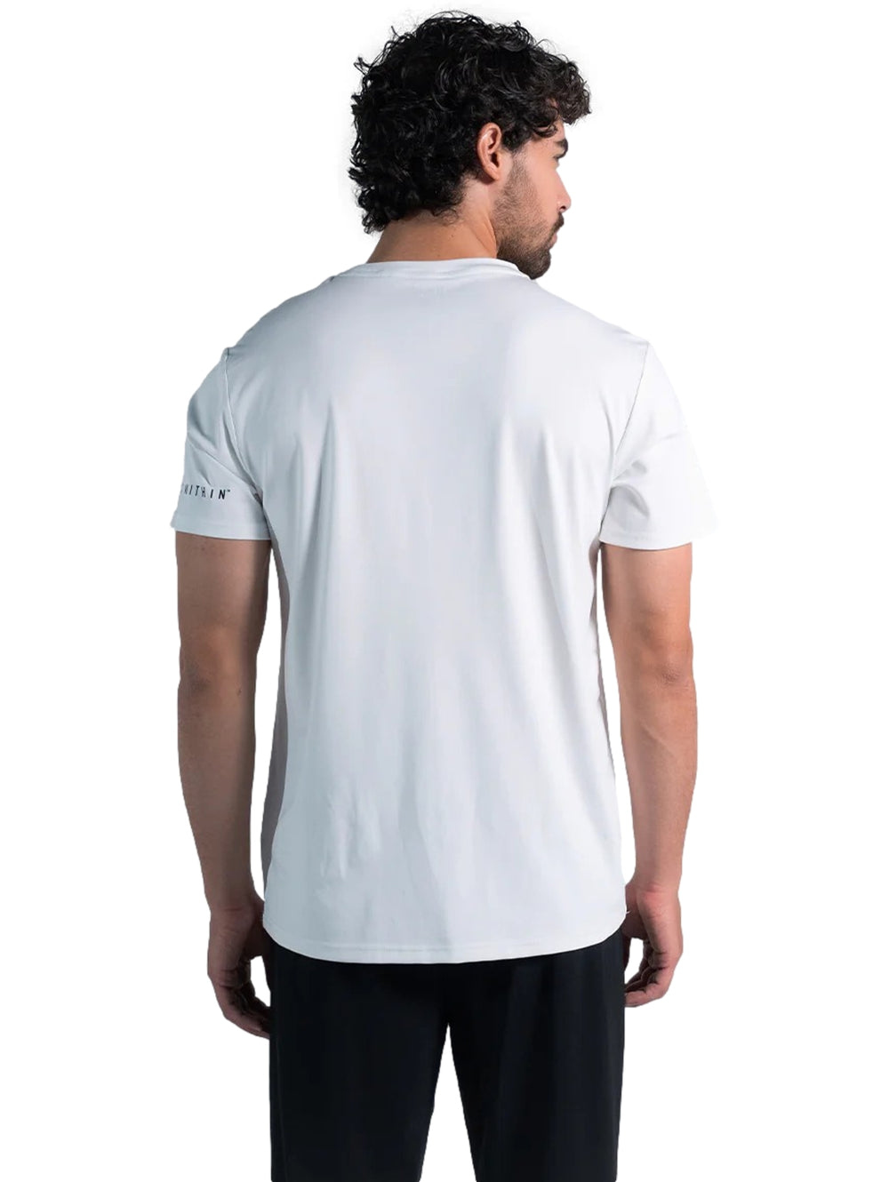 Hombre modelando una playera deportiva blanca de manga corta marca Everlast y pantalones negros.