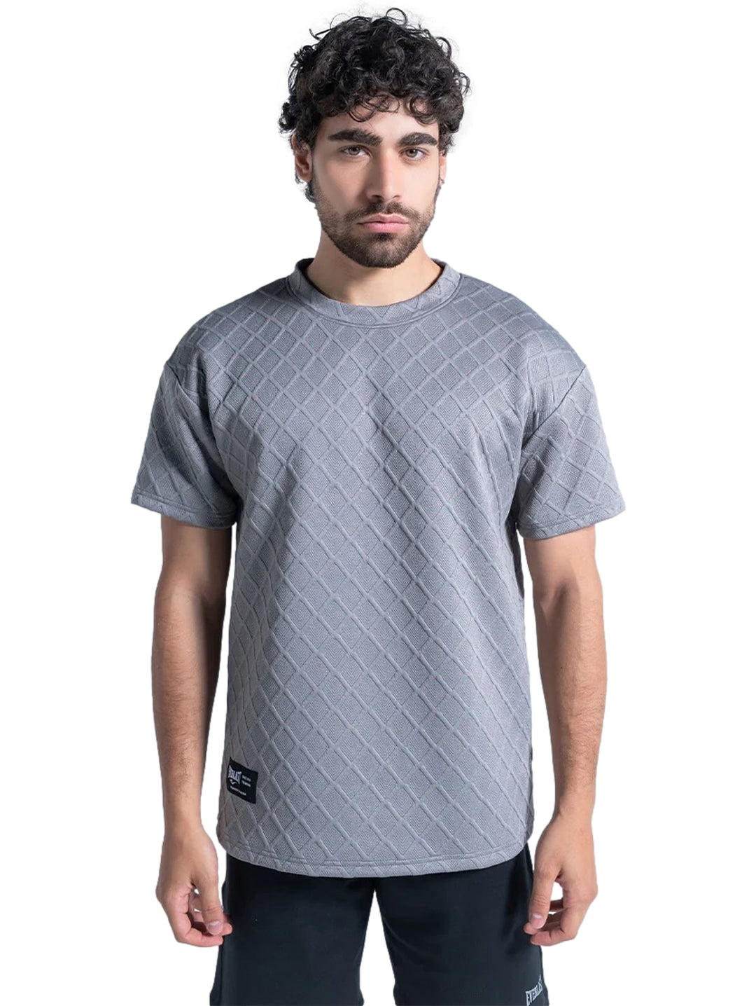 Hombre vistiendo playera deportiva Everlast color gris con textura de rombos.