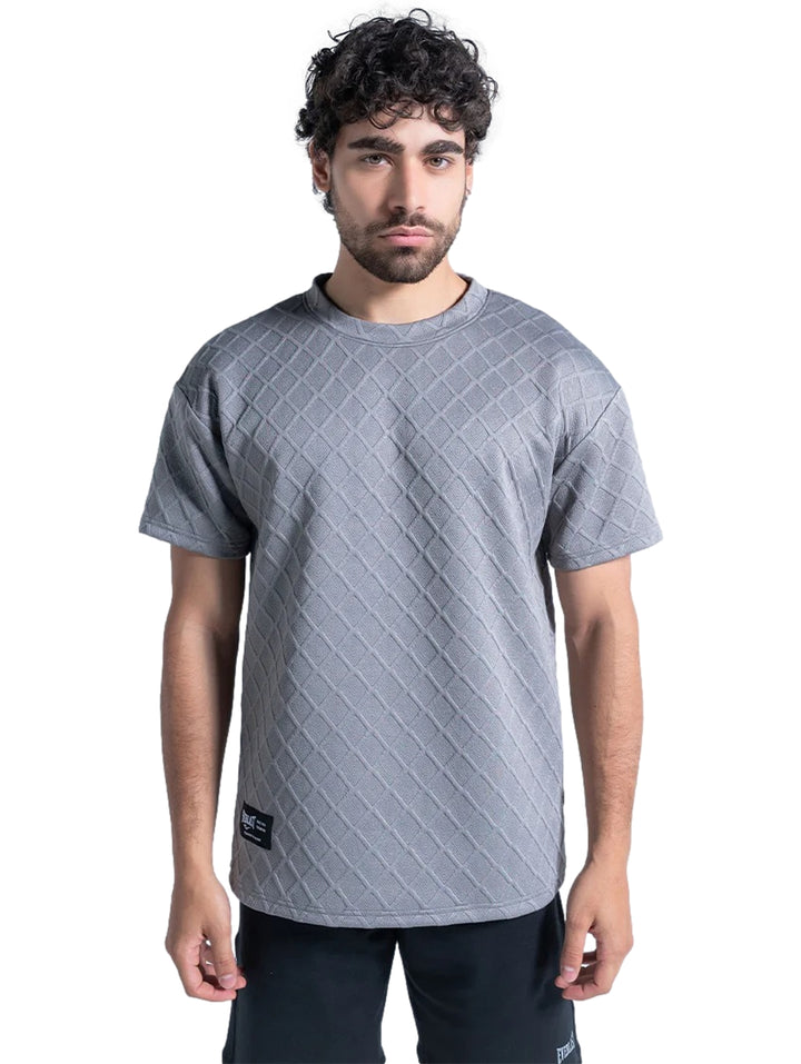 Hombre vistiendo playera deportiva Everlast color gris con textura de rombos.