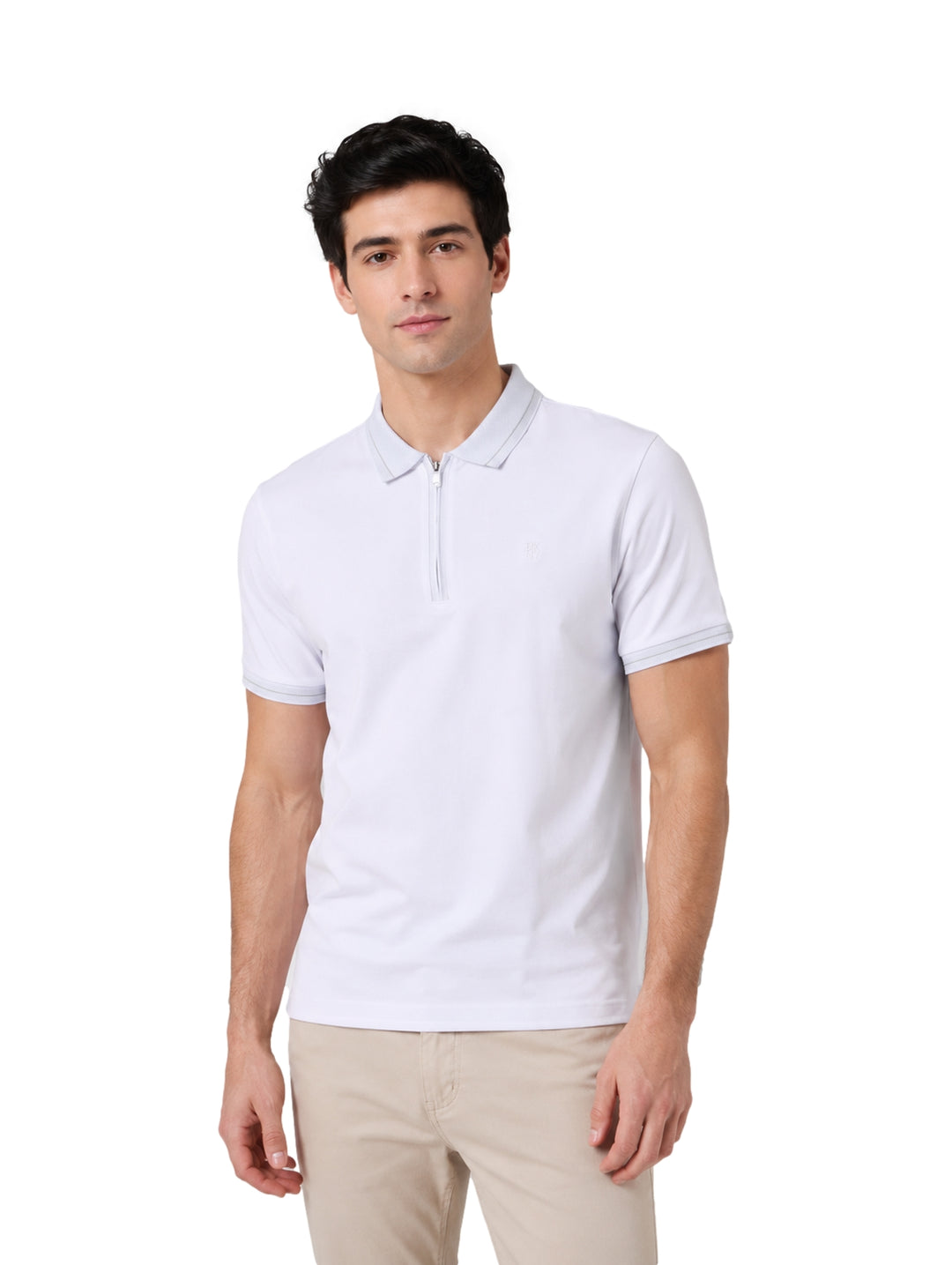 Hombre vistiendo una playera polo blanca de manga corta marca DKNY y pantalones beige.