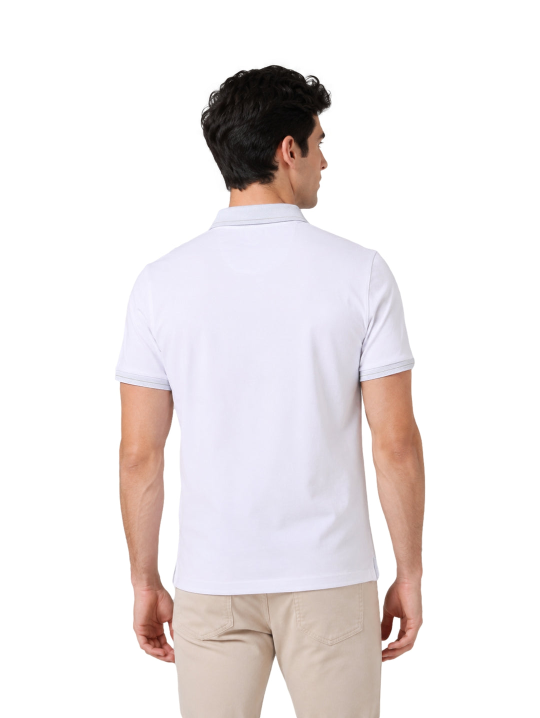 Hombre vistiendo una playera polo blanca de manga corta marca DKNY y pantalones beige.